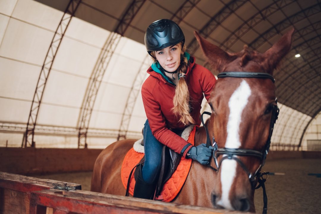 pretty-young-woman-riding-a-horse-in-the-arena-for-equestrian-sport.jpg