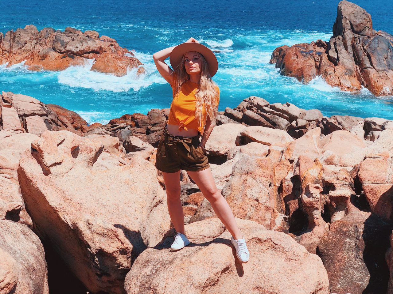 beautiful-blonde-traveler-girl-wearing-hat-and-yellow-t-shirt-at-the-rocky-beach-in-australia.jpg